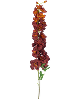 Den kunstige blomst Delphinium 105 cm bordeaux har en lang, enkelt stilk med flere mørkerøde og orange kunstige blomster og grønne blade, isoleret på en hvid baggrund.
