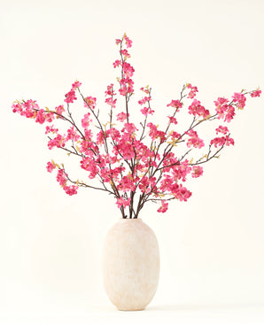 Silke kunstige blomsterbuketten Cherry blossom fuchsia 150 cm har livlige fuchsia kirsebærblomststængler med grønne blade i en simpel hvid vase, som vil komplementere ethvert interiør på en lys baggrund.