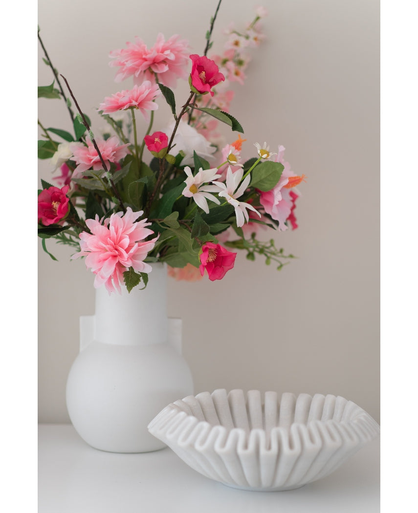 Een witte vaas met een Kunstbloem Rododendron Azalea 73 cm fuchsia staat naast een witte schaal van geribbeld keramiek op een effen ondergrond tegen een neutrale achtergrond.