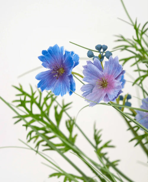 Artificial Grass lilla Gesang Flower løggræspotte (56 cm, brandhæmmende) har sarte lilla blomster med grønne bregne-lignende blade og små runde knopper, mod en almindelig hvid baggrund.
