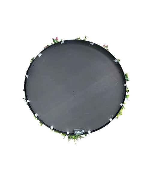 En kunstig hæk på sort stel Ø100 cm trampolin, set fra oven med grønne blade og lyserøde blomster rundt i kanten, mod hvid baggrund.