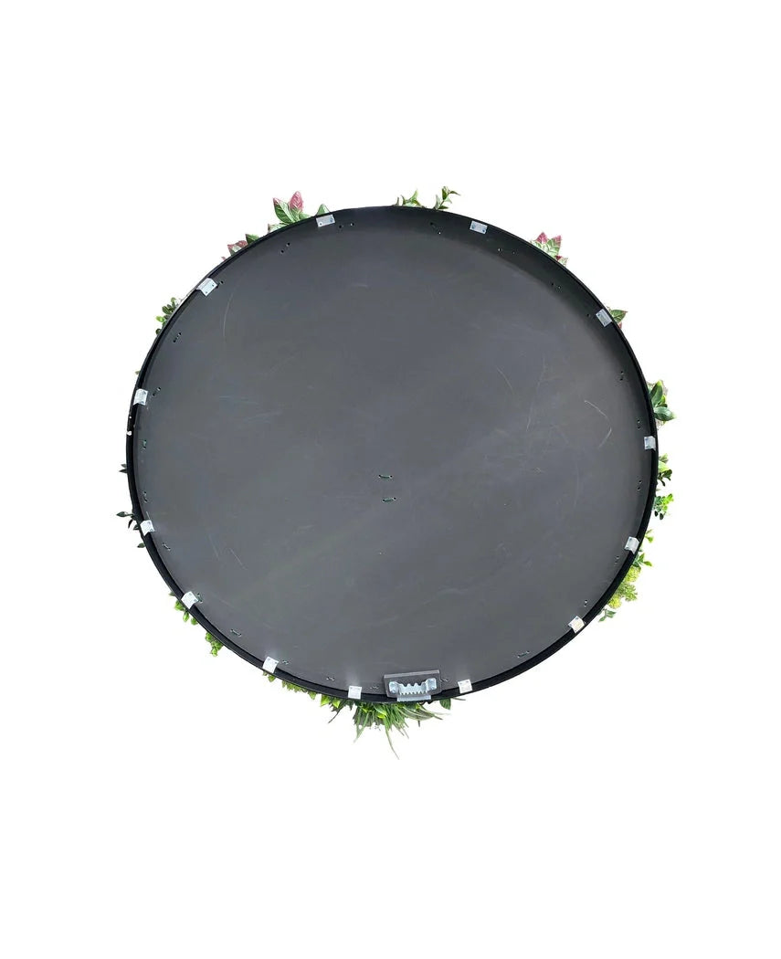Een Kunsthaag op Zwart Frame Ø100 cm trampoline, van bovenaf gezien met groene bladeren en roze bloemen rond de rand, tegen een witte achtergrond.