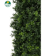 Et nærbillede af frodig grøn kunstig plante buksbom Pyramid UV 90 cm løv med blanke blade. Et sol- og UV-ikon i hjørnet understreger UV-beskyttelsen til brug som udendørs eller indendørs haveplante.