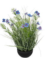 En sort potte med kunstgræs lilla Gesang Blomsterløggræspotte 56cm brandhæmmende, med høje grønne græslignende blade og blålilla blomster, mod en almindelig hvid baggrund.