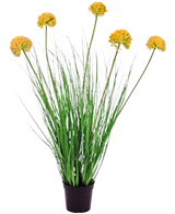 Artificial Gras Plant Onion 70 cm brandhæmmende middel har lange, tynde grønne blade og høje stængler med runde gule blomsterklaser, så den skiller sig smukt ud mod en hvid baggrund.