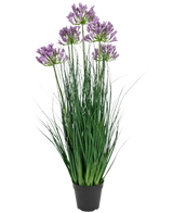 The Artificial Grass Purple Agapanthus Onion Grass Pot er en 90 cm høj, brandhæmmende kunstig plante med lange grønne blade og bundter af lilla blomster, udstillet i en almindelig sort potte mod en hvid baggrund.