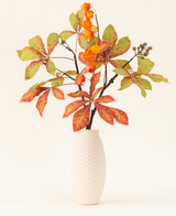 Silke kunstige blomsterbuketten Autumn Flair har en vase med hvid struktur og lanternegren, orange lanterneformede blomster og grøn-røde blade, som danner en stilfuld efterårsudstilling mod en almindelig lys baggrund.