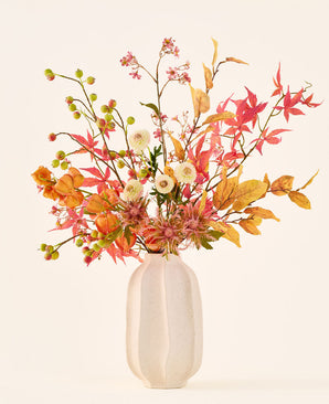 Kunstig silkeblomstbuket 'Autumn Breeze' i en hvid keramikvase, med et arrangement af efterårsblade, små grønne bær, lyserøde blomster og hvide blomster, lavet af højkvalitets silkeblomster. Placeret mod en lys baggrund – den perfekte kunstige blomsterbuket til at give ethvert rum en langvarig sæsonbestemt atmosfære.