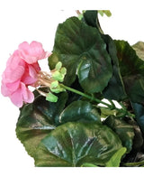Et nærbillede af den kunstige geranium 40 cm pink, med flere grønne blade mod en hvid baggrund.
