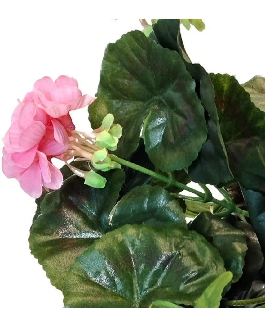 Et nærbillede af den kunstige geranium 40 cm pink, med flere grønne blade mod en hvid baggrund.