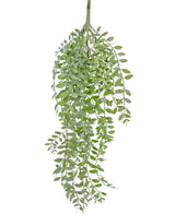 De Kunst hangplant Pumila/Eucalyptus 76 cm heeft een lange groene tak met meerdere kleinere stengels en ovaalvormige bladeren, die allemaal naar beneden hangen tegen een witte achtergrond.