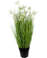 Den kunstige græsrodsblomster Løggræs 90 cm brandhæmmende har lange, slanke grønne blade og sarte hvide blomsterklaser i en potte, mod en almindelig hvid baggrund.