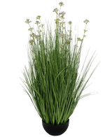 Kunstgræs Porre Blomster Løg Græspotte 100 cm brandhæmmende har en sort potte med høje, tynde grønne kunstige blade og små lilla blomster på lange stængler, mod en hvid baggrund.